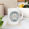 White mug with a paw print design and 'Conscious Being' text on a coaster.