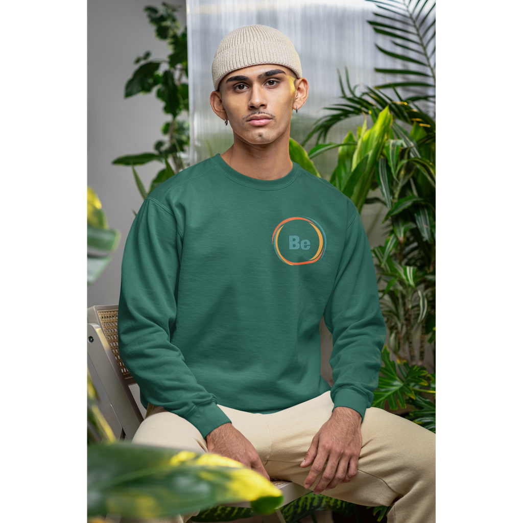 Person wearing a green sweatshirt with a logo sitting among plants