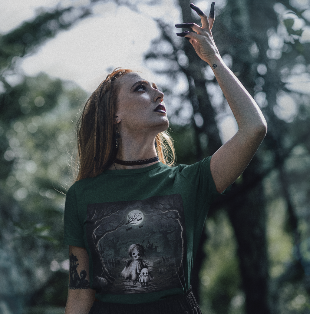 woman wearing a green t-shirt with a ghost and skeleton graphic design
in a forest.
