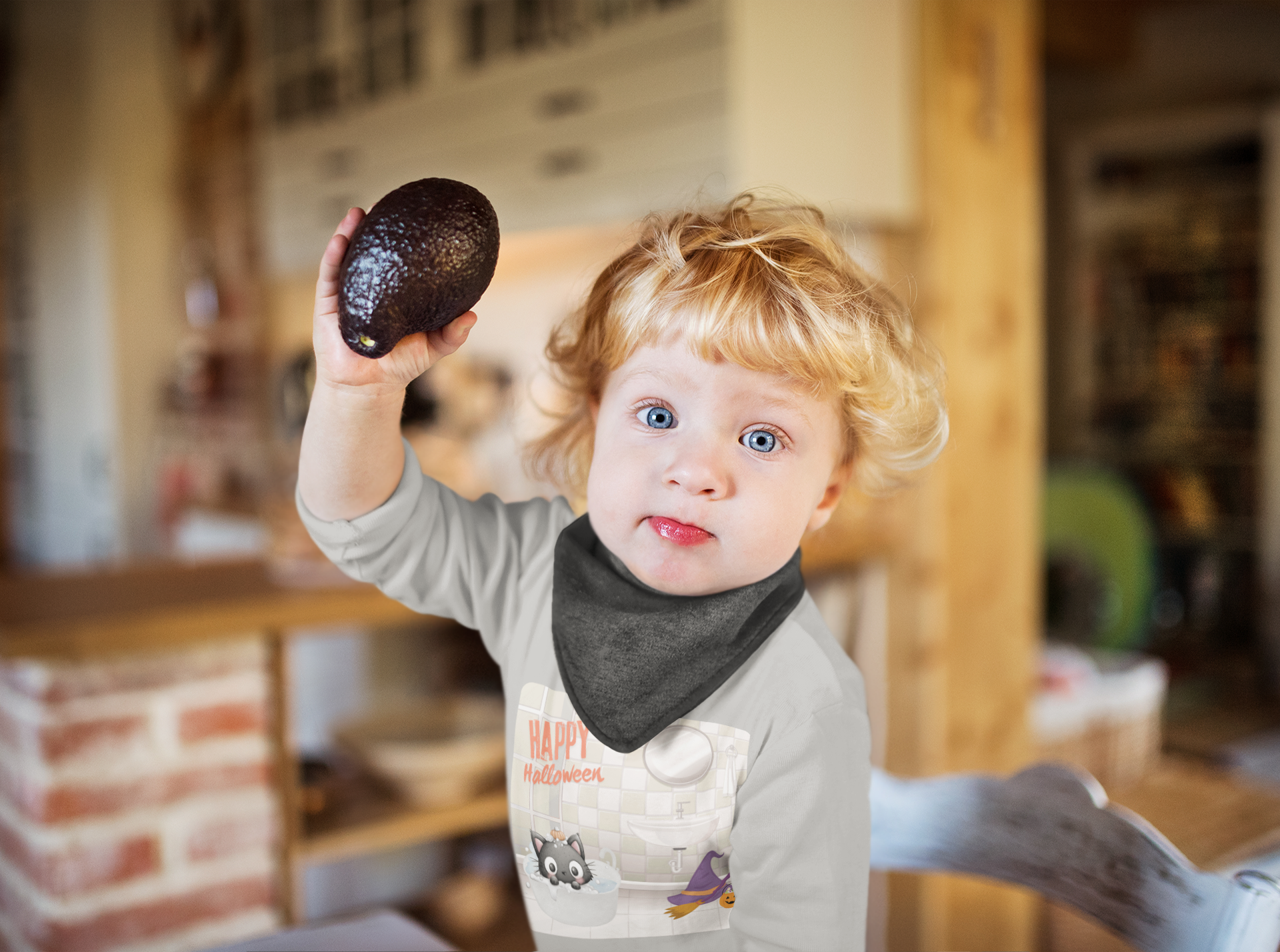 Child holding an avocado in a kitchen setting