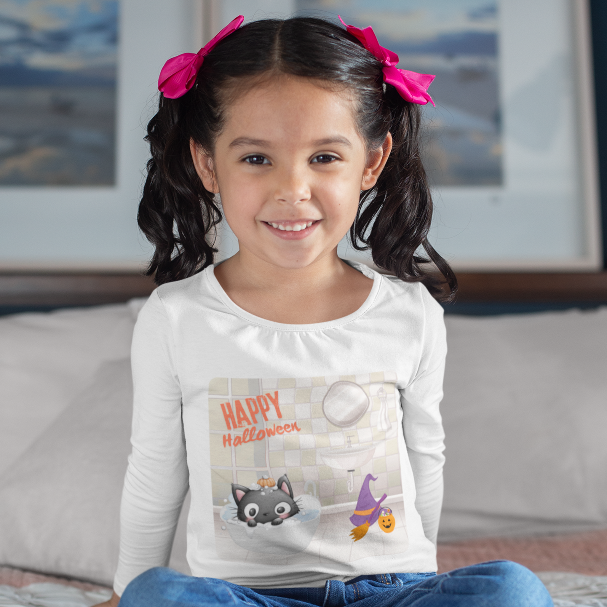 Young girl wearing a 'Happy Halloween' shirt with a cat and witch design, sitting on a couch.