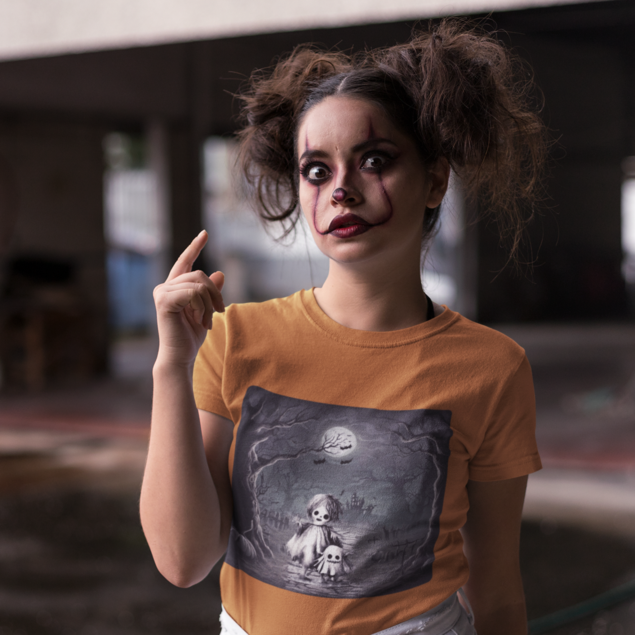 Person wearing a auburn color t-shirt with a graphic design, pointing upwards.