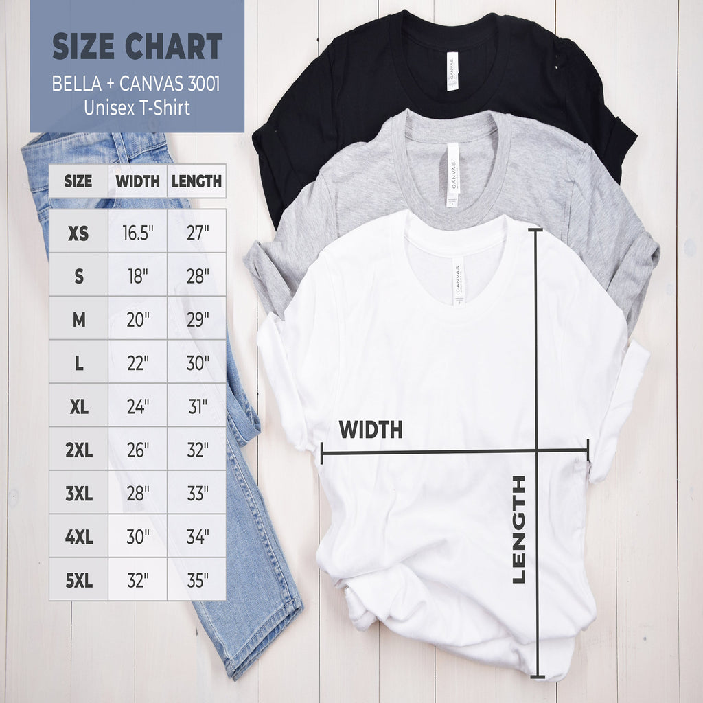 Size chart for Bella + Canvas 3001 unisex t-shirts with shirts and jeans on a wooden surface.