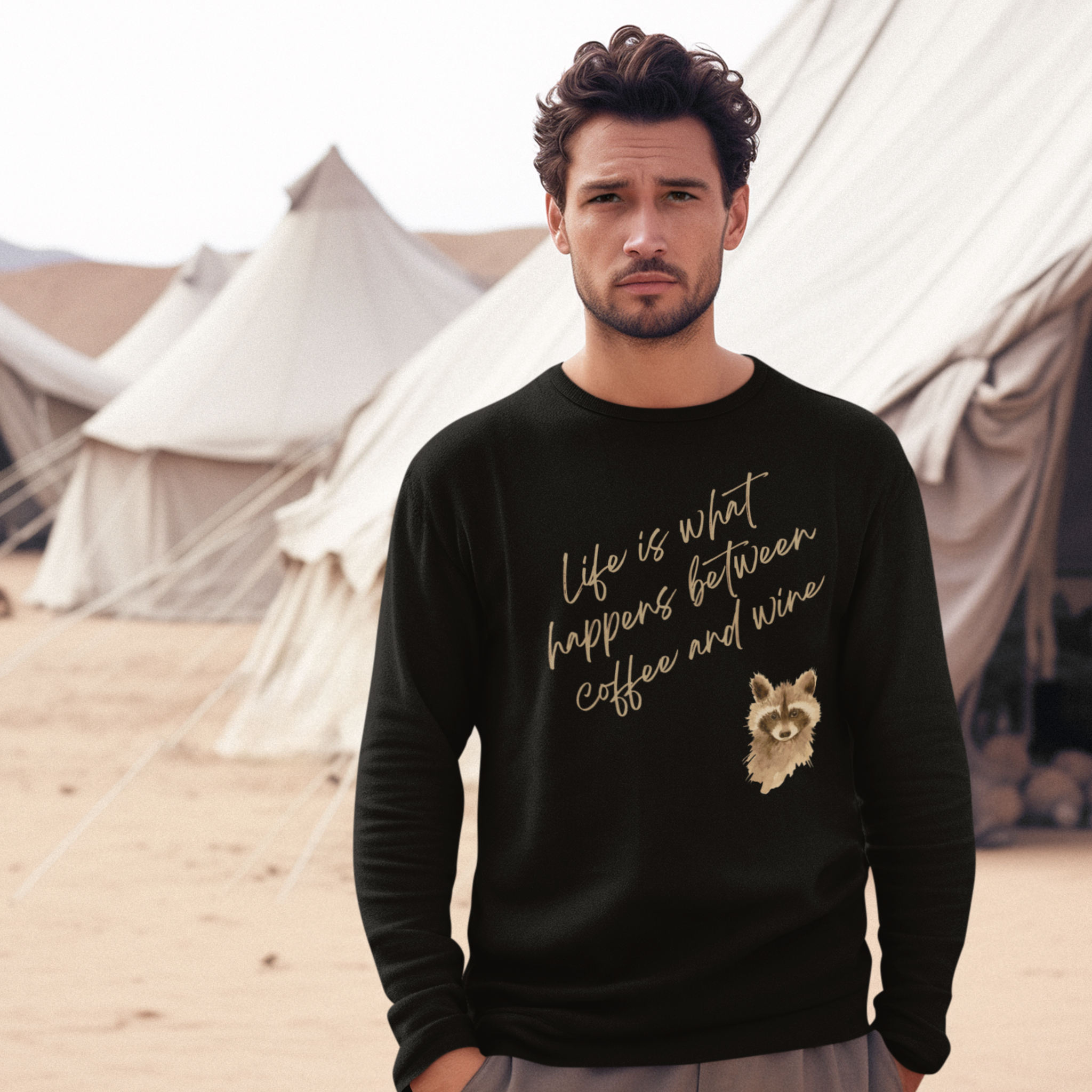 Man wearing a black sweatshirt with text and a raccoon graphic, standing in front of white tents.