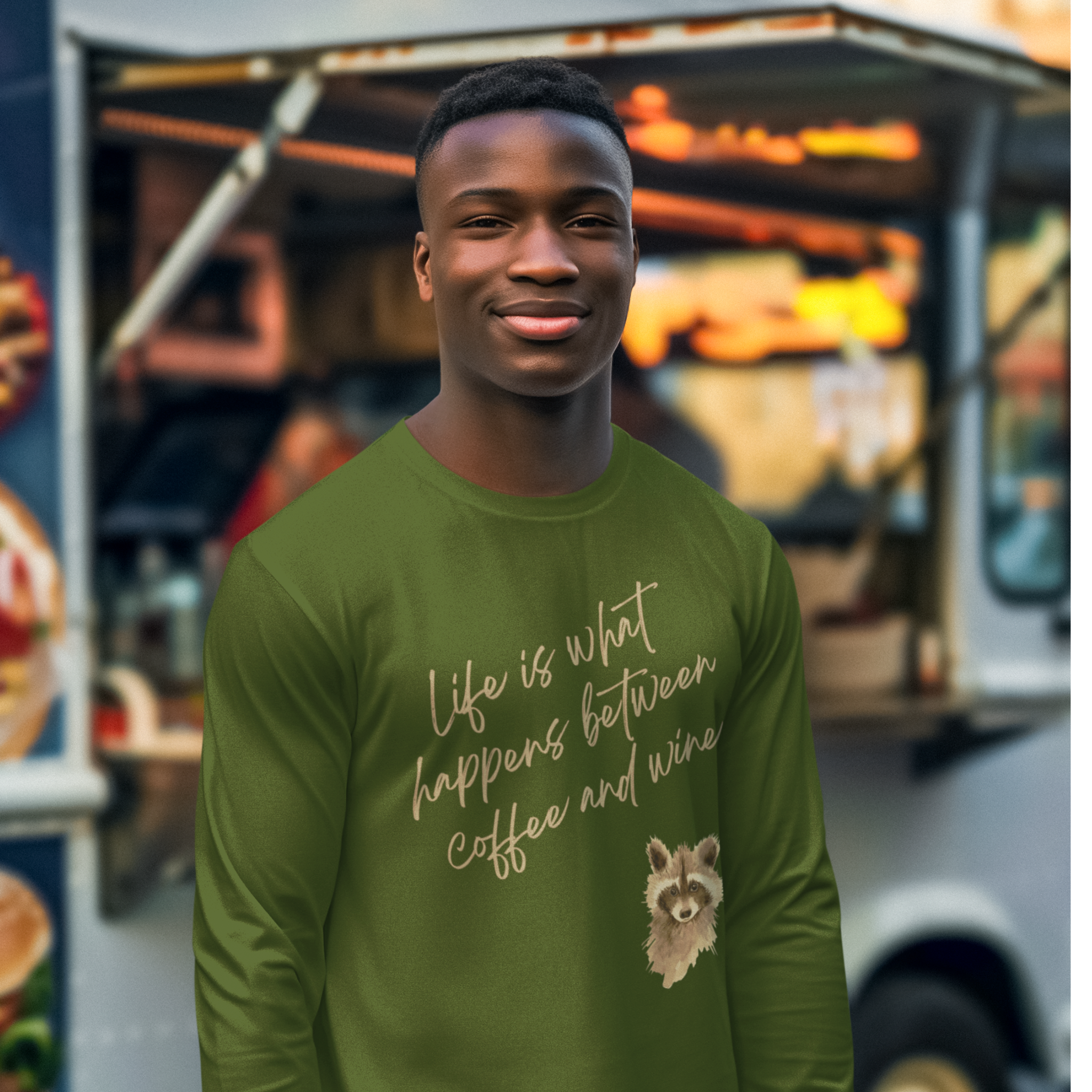 Man wearing a green shirt with a quote and raccoon graphic in front of a food truck.