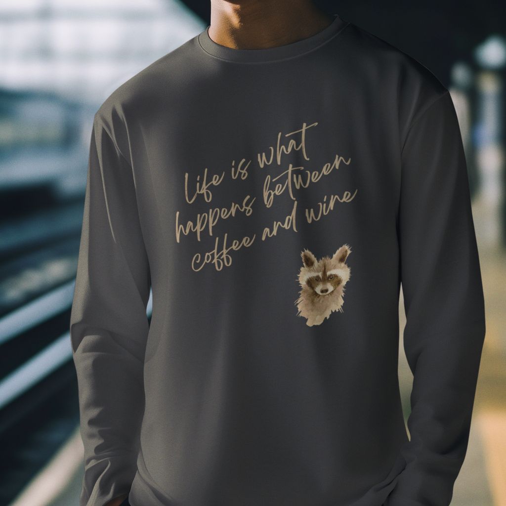 Person wearing a dark gray sweatshirt with a raccoon illustration and text.