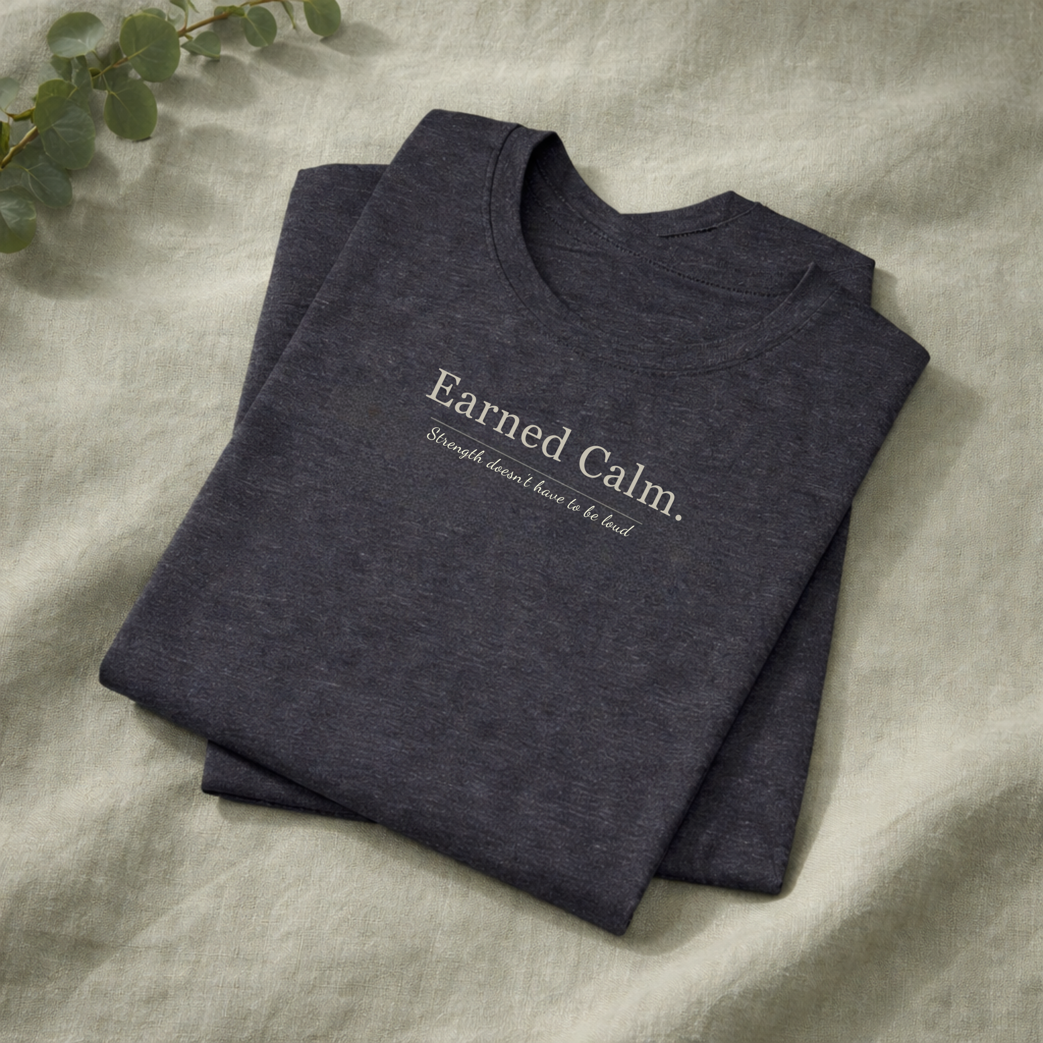 Earned Calm minimalist t-shirt featuring a quiet strength quote. Soft, modern unisex tee designed for calm confidence and everyday wear.